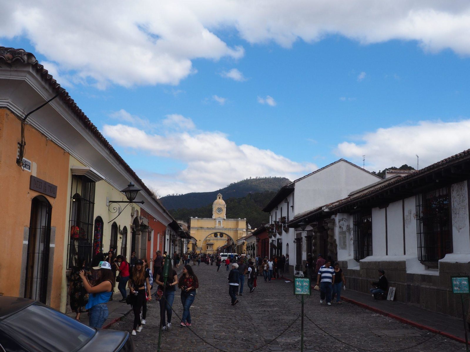 Tourists visiting Guatemala walking down a cobblestone street.