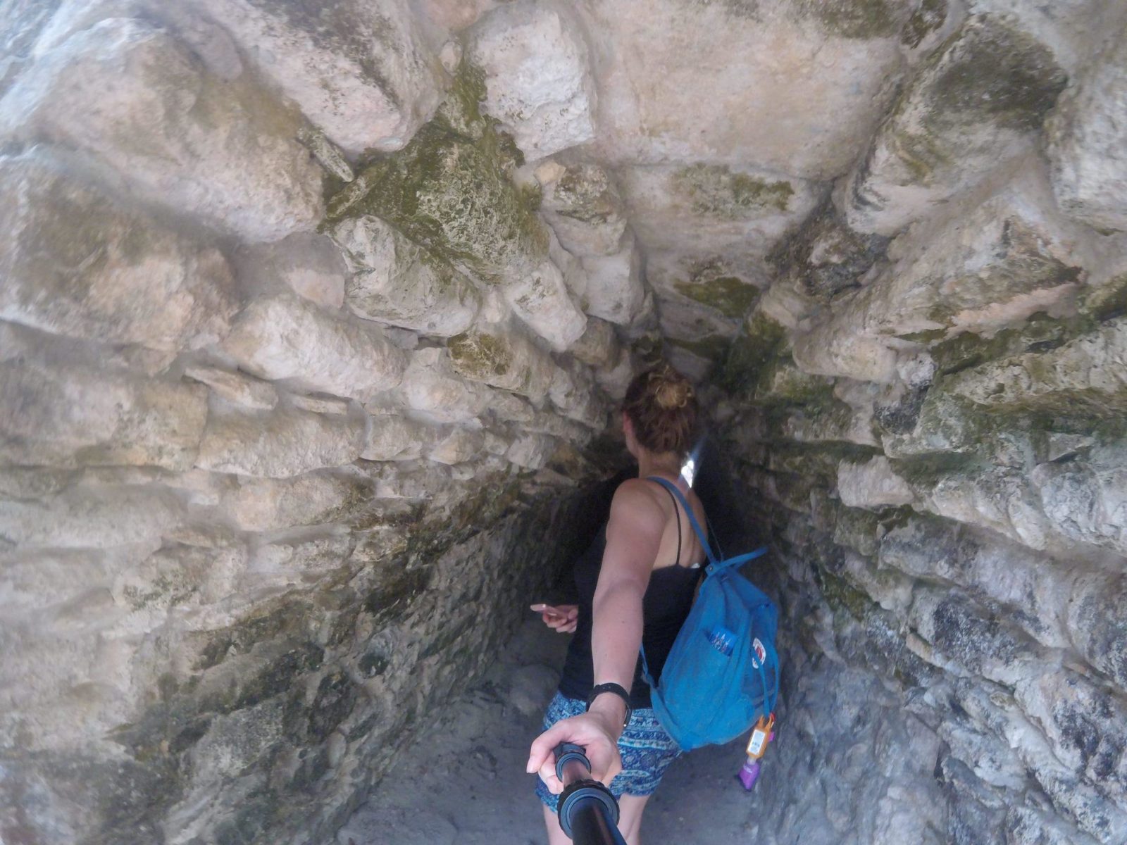 A woman exploring the Coba Ruins with a backpack.