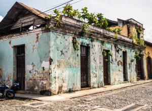 A motorcycle is parked in front of an old building during 4 days in Antigua.