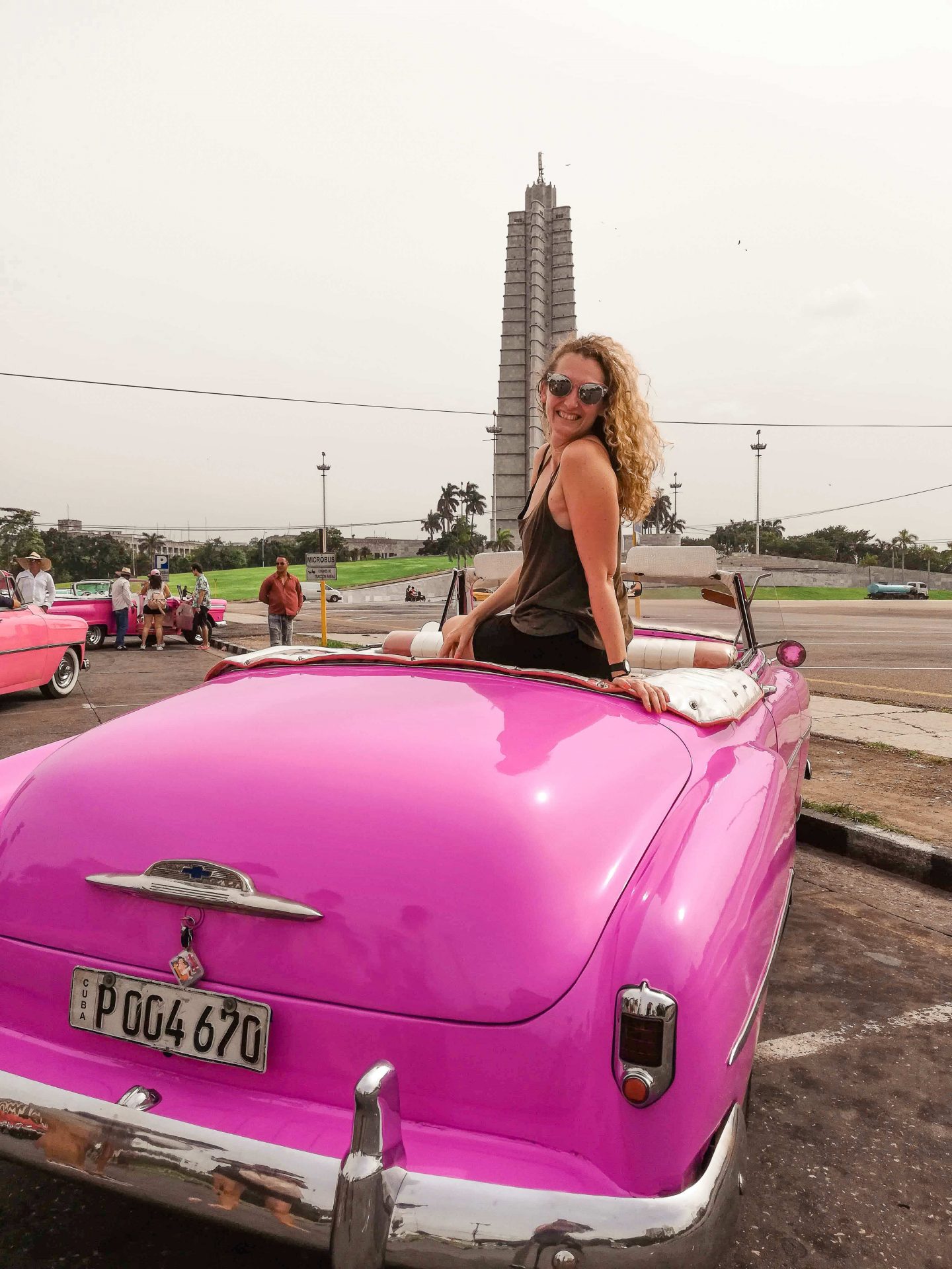 A woman enjoys the vibrant atmosphere of Havana from the back of a pink convertible car during her 48 hours in the city.