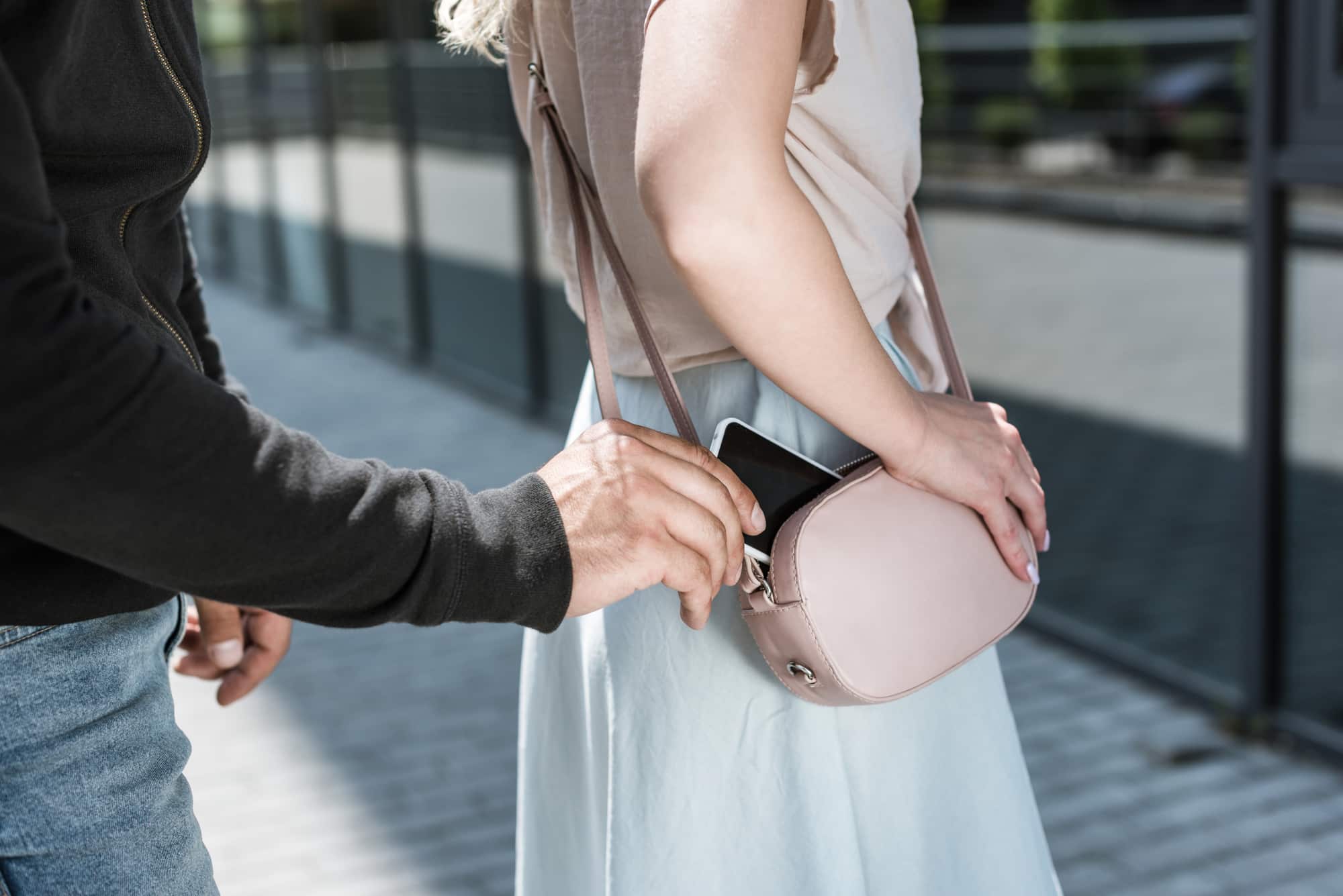 A man is holding a pink purse while a woman is standing next to him.