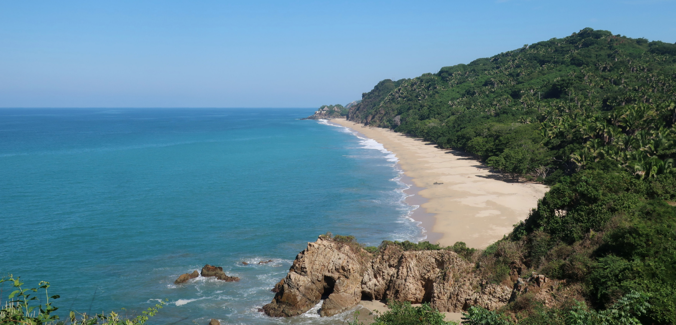 A Sayulita travel guide to a beach with a rocky coastline and a sandy beach.