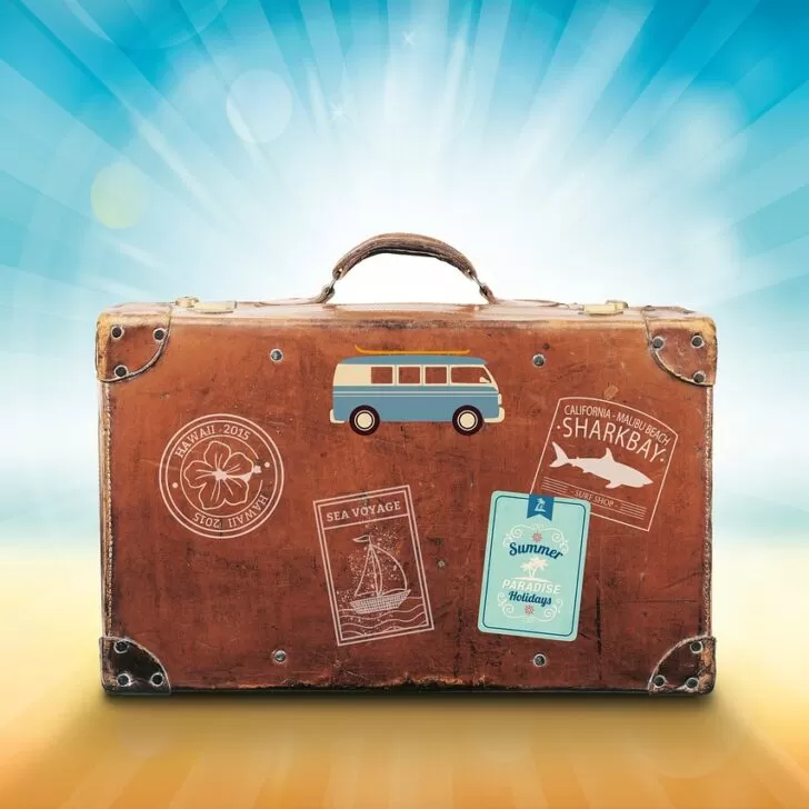 A brown suitcase on a beach.