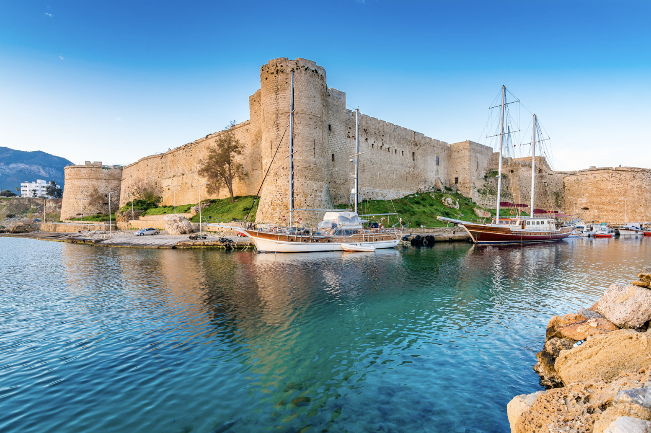 A castle overlooking a boat docked in the water, offering an impressive setting for an all-inclusive holiday.