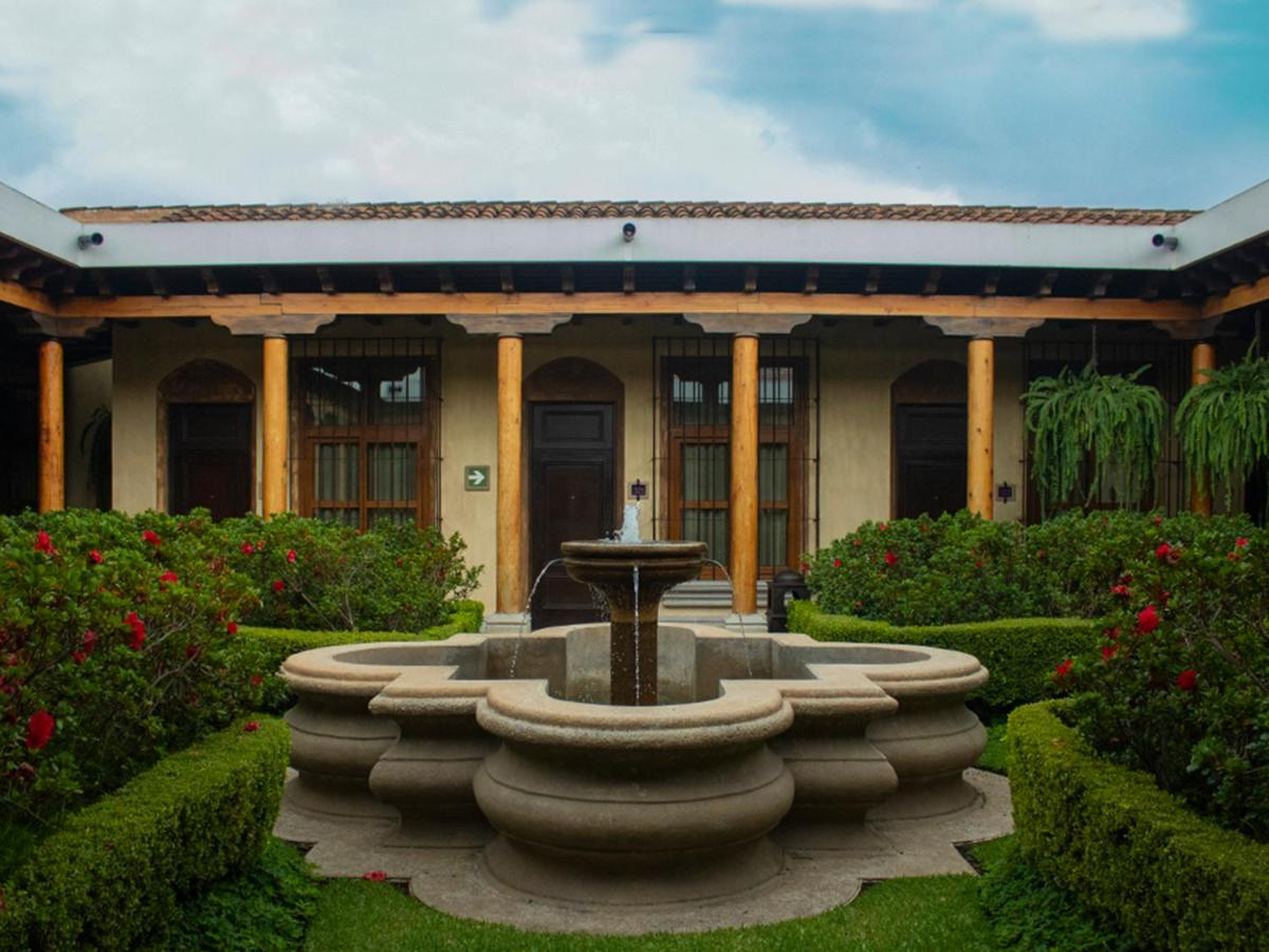 A serene courtyard with a beautiful fountain in front of a charming house in Antigua Guatemala.