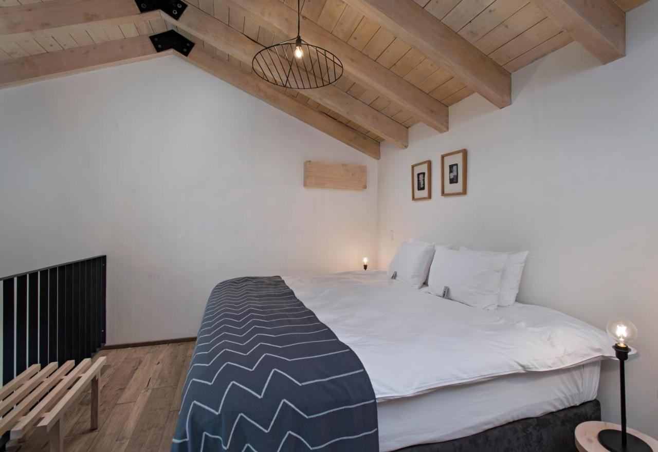 A cozy bedroom with wooden beams and a comfortable bed.