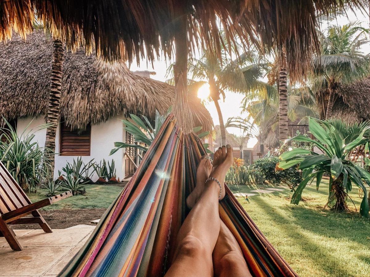 A person's legs relaxing in a hammock amidst the pristine beaches of El Paredon, Guatemala.