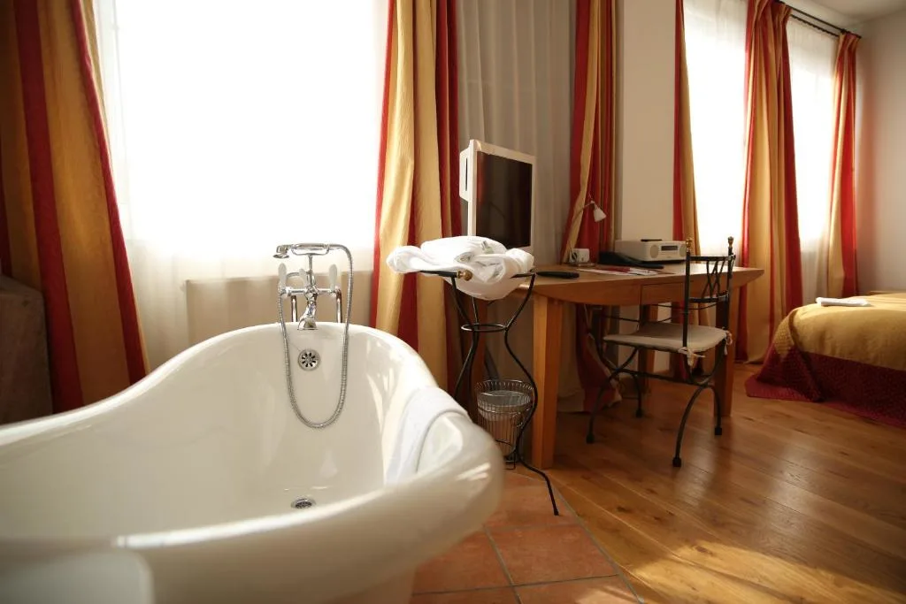 Bright room with bathtub, desk, and colorful curtains