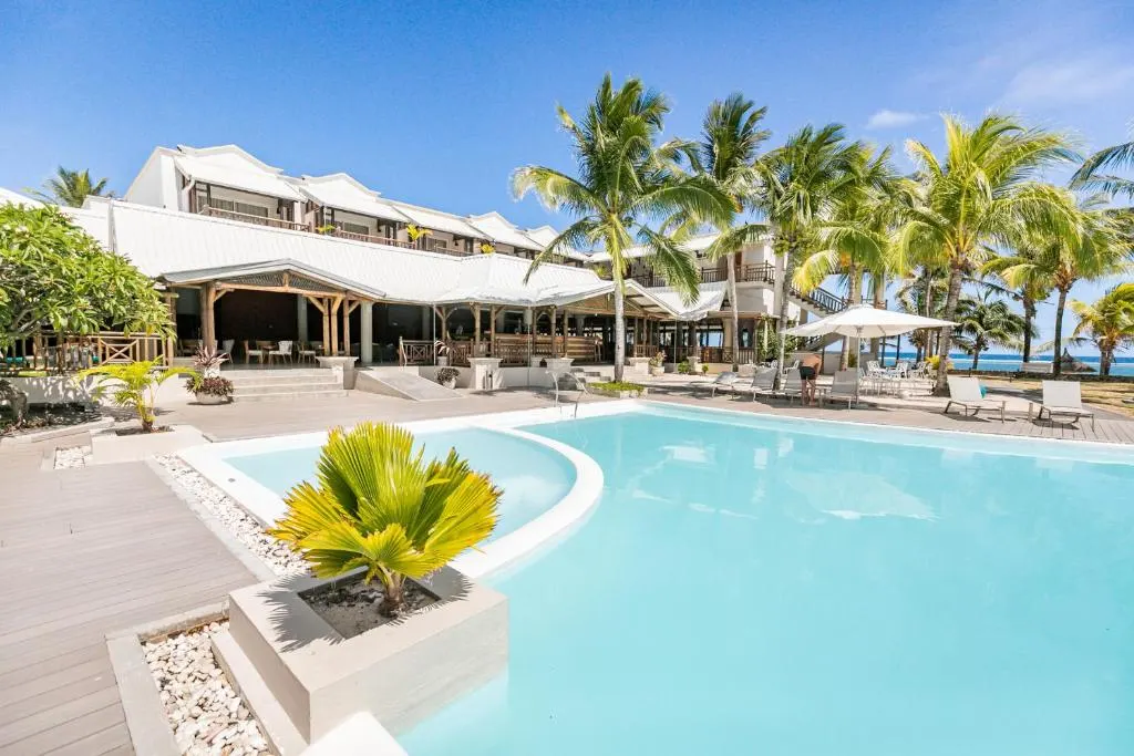 Tropical resort with pool, palm trees, and ocean view