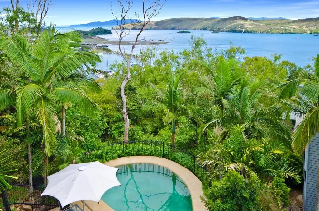 Scenic coastal view over pool surrounded by lush greenery