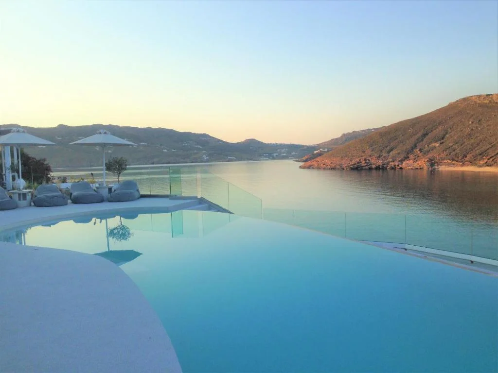 Infinity pool overlooking serene bay at sunset