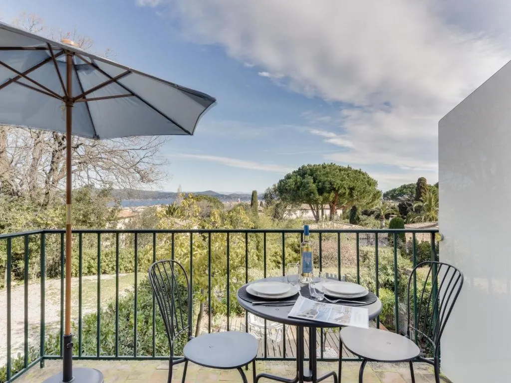 Scenic balcony dining setup overlooking lush garden and hills