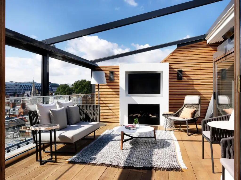 Modern rooftop patio with outdoor fireplace and city view