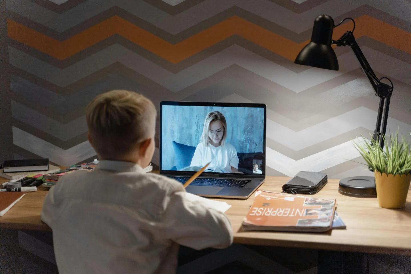 Child engaging in online class from home office