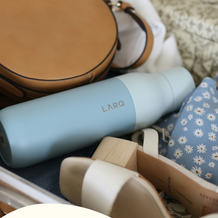 Travel essentials in suitcase including water bottle and shoes