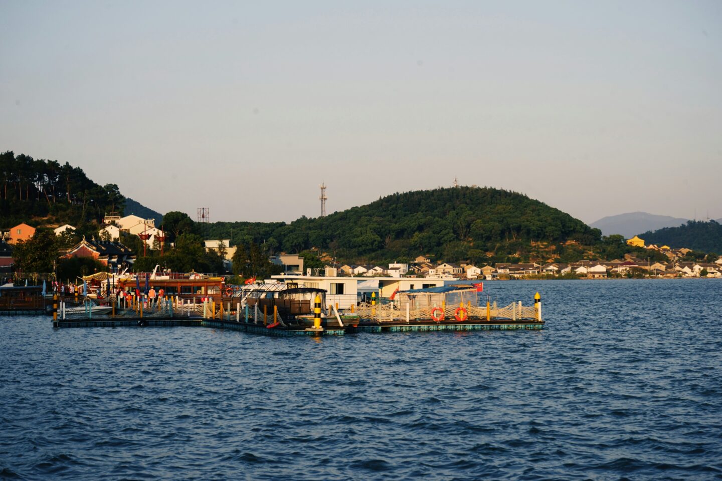 Floating pier with people at seaside during sunset