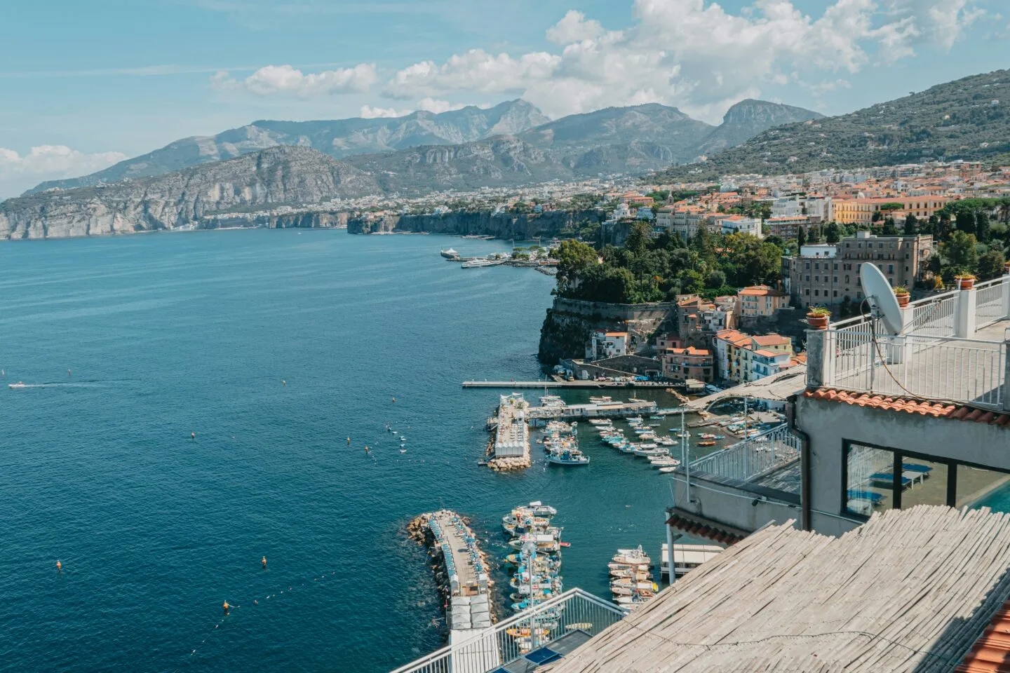 Scenic view of a coastal town with boats and cliffs