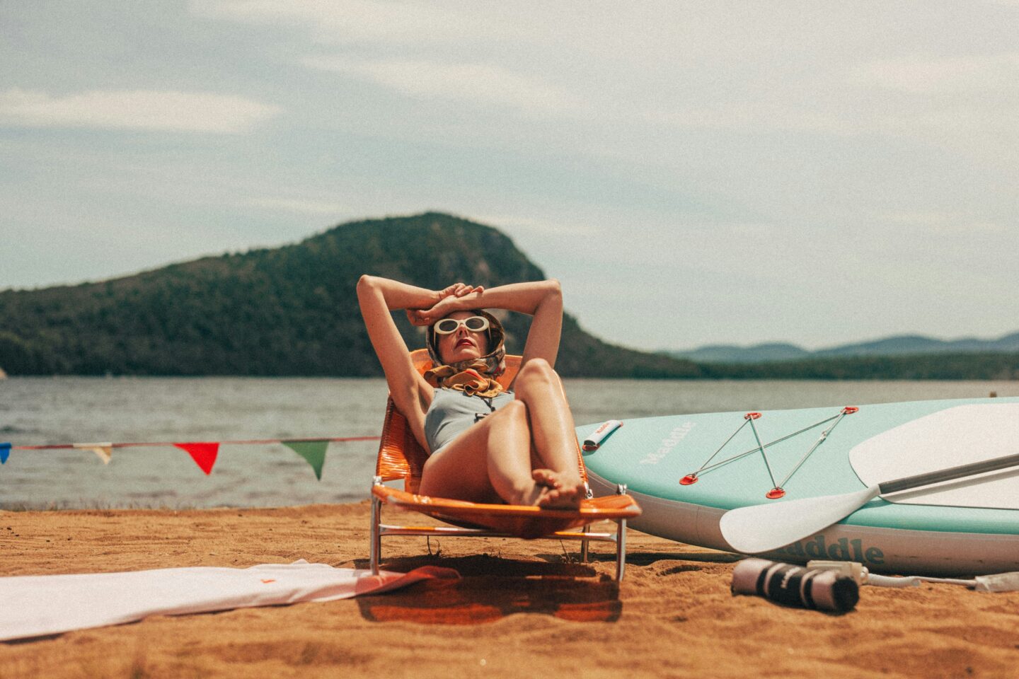 Woman relaxing on beach chair near lake
