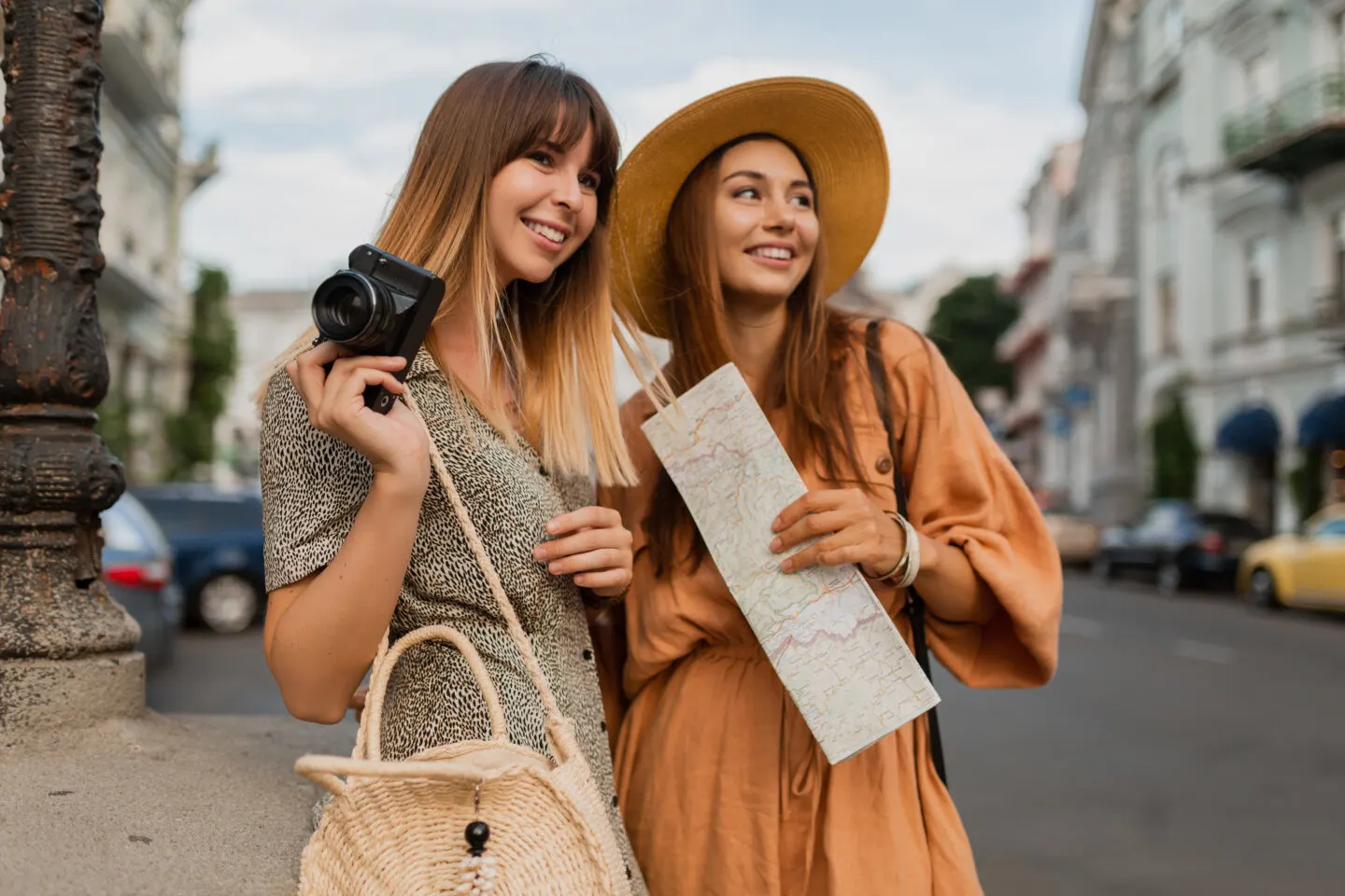Two women exploring city with camera and map