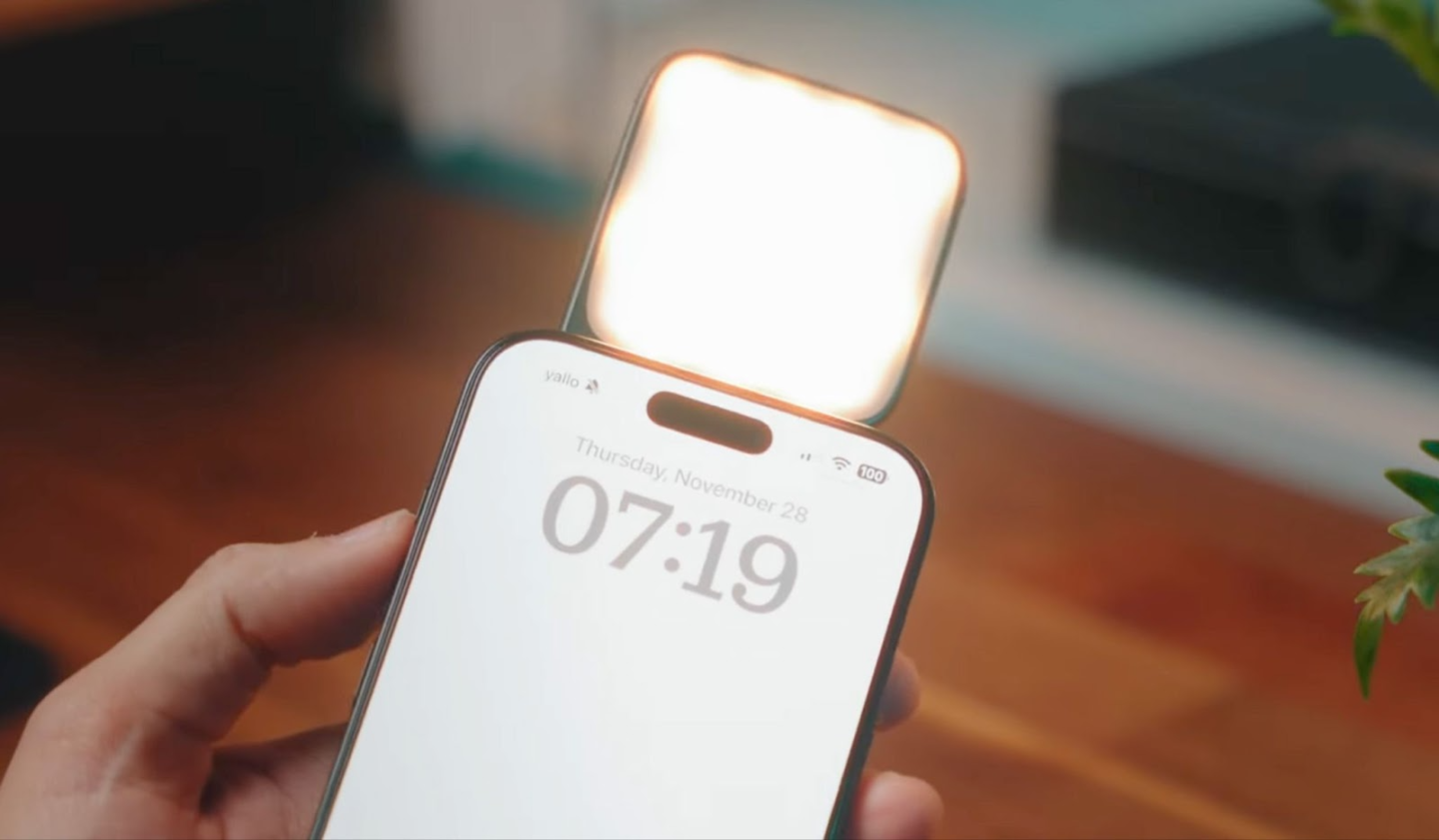 Smartphone displaying time with light accessory behind