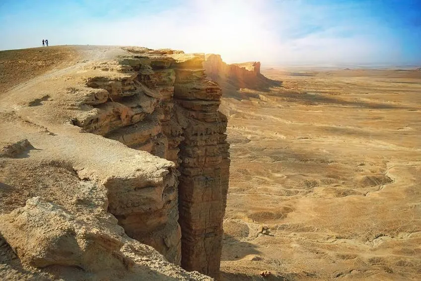 Sunlit desert cliff with expansive arid view