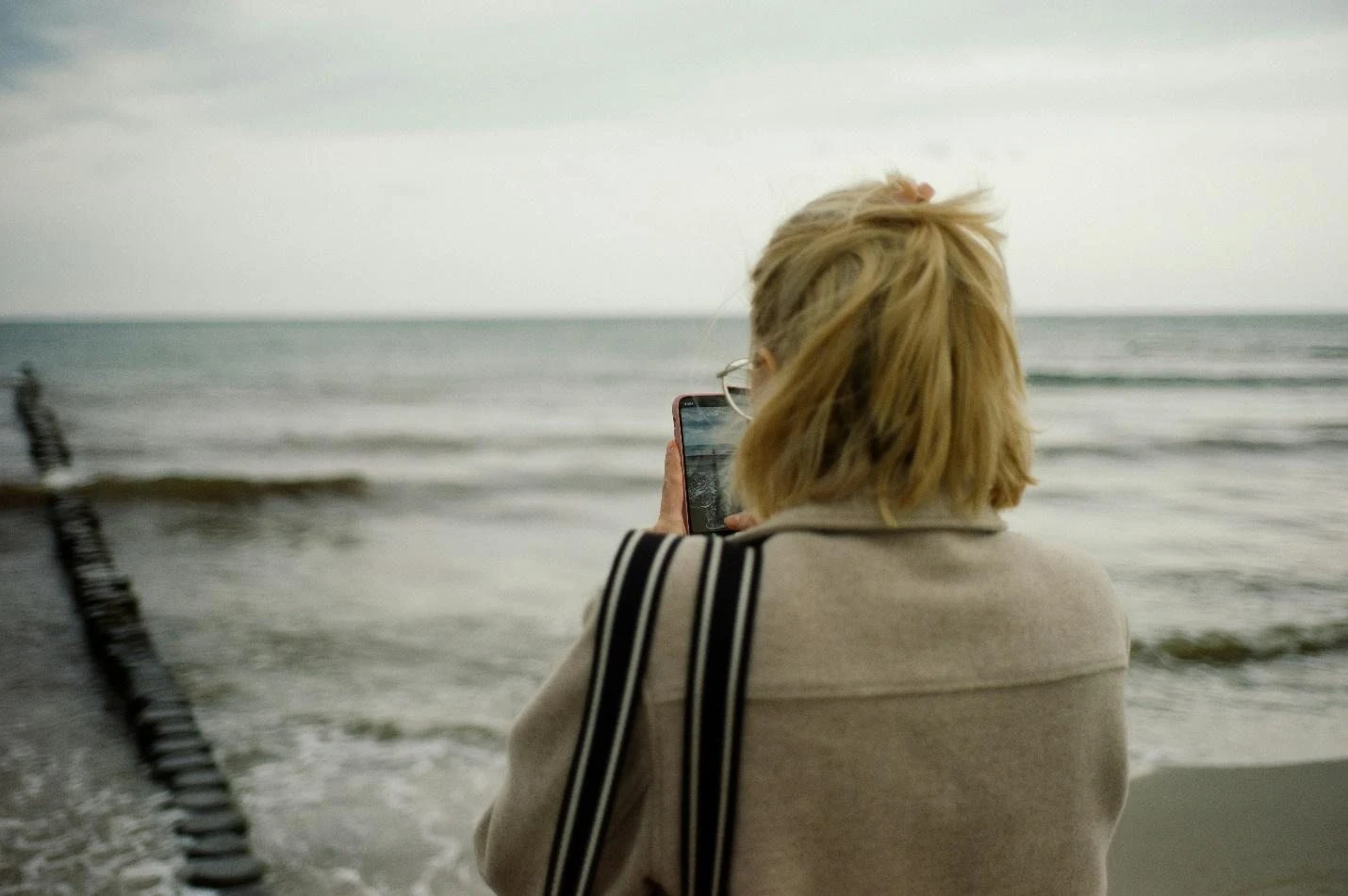 Woman taking photo of sea with smartphone