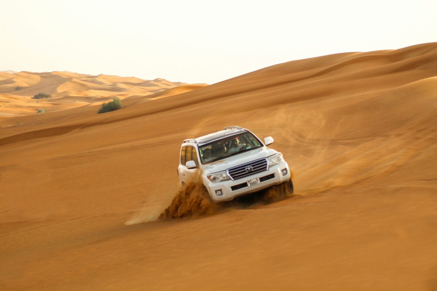 SUV driving on sandy desert dunes