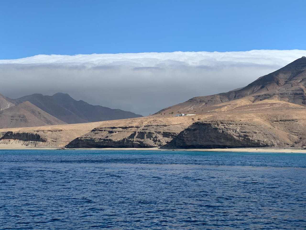Coastal landscape with mountains, sea, and cloudy sky