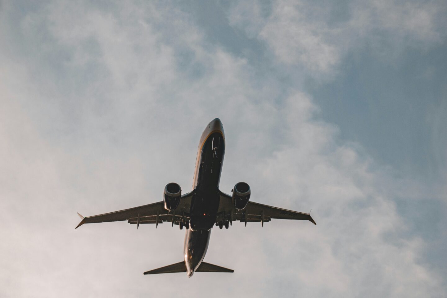 Airplane flying against cloudy sky