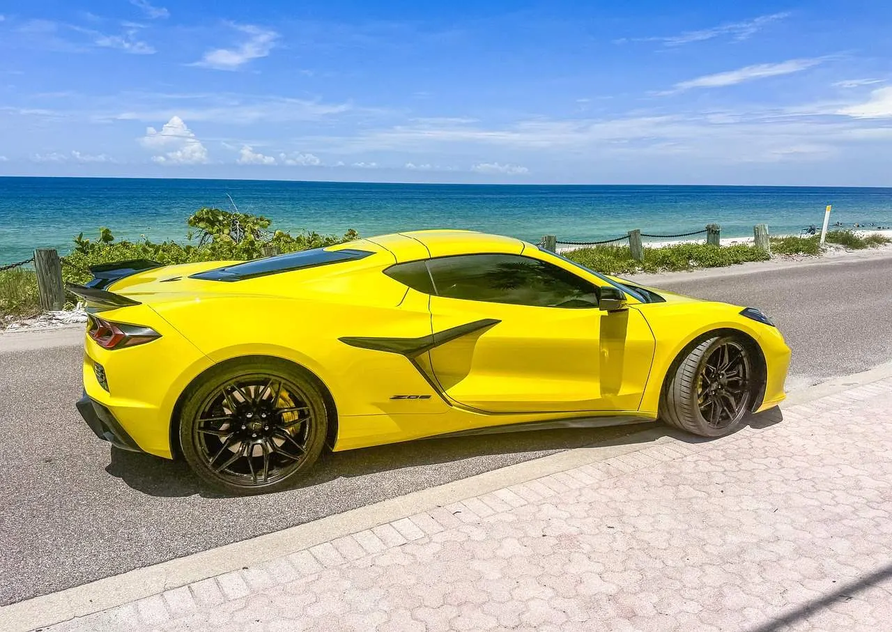 Yellow sports car parked beside beach road