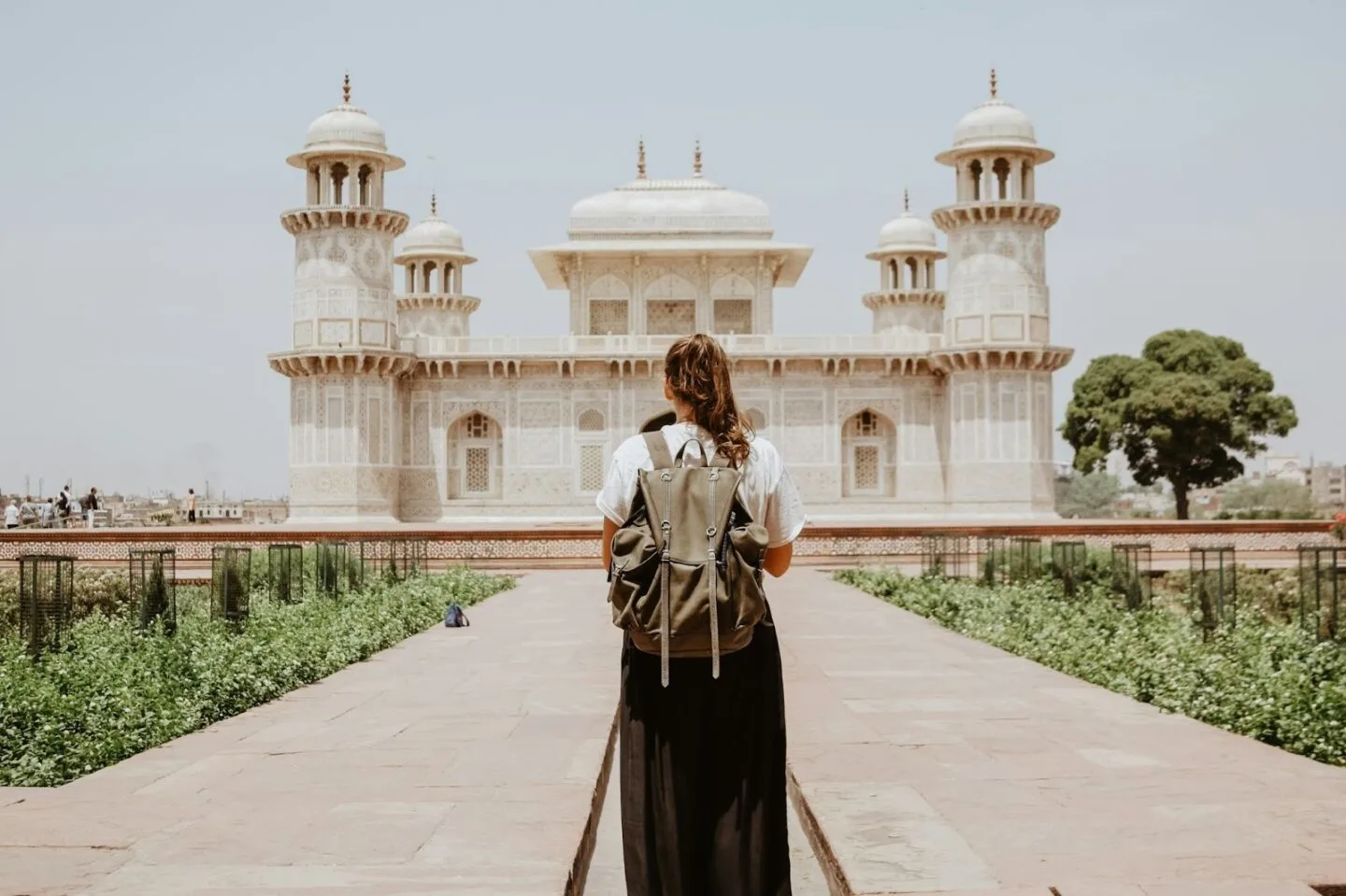 Woman with backpack viewing grand white marble building