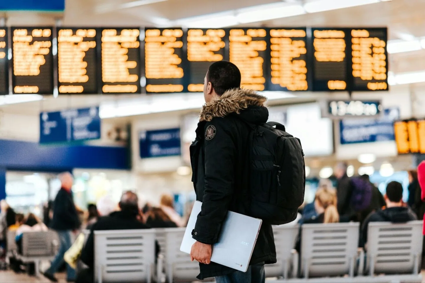Man with backpack checking flight times at airport