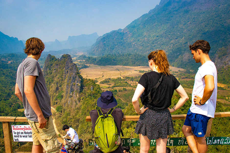 Tourists overlooking scenic mountain valley from viewpoint