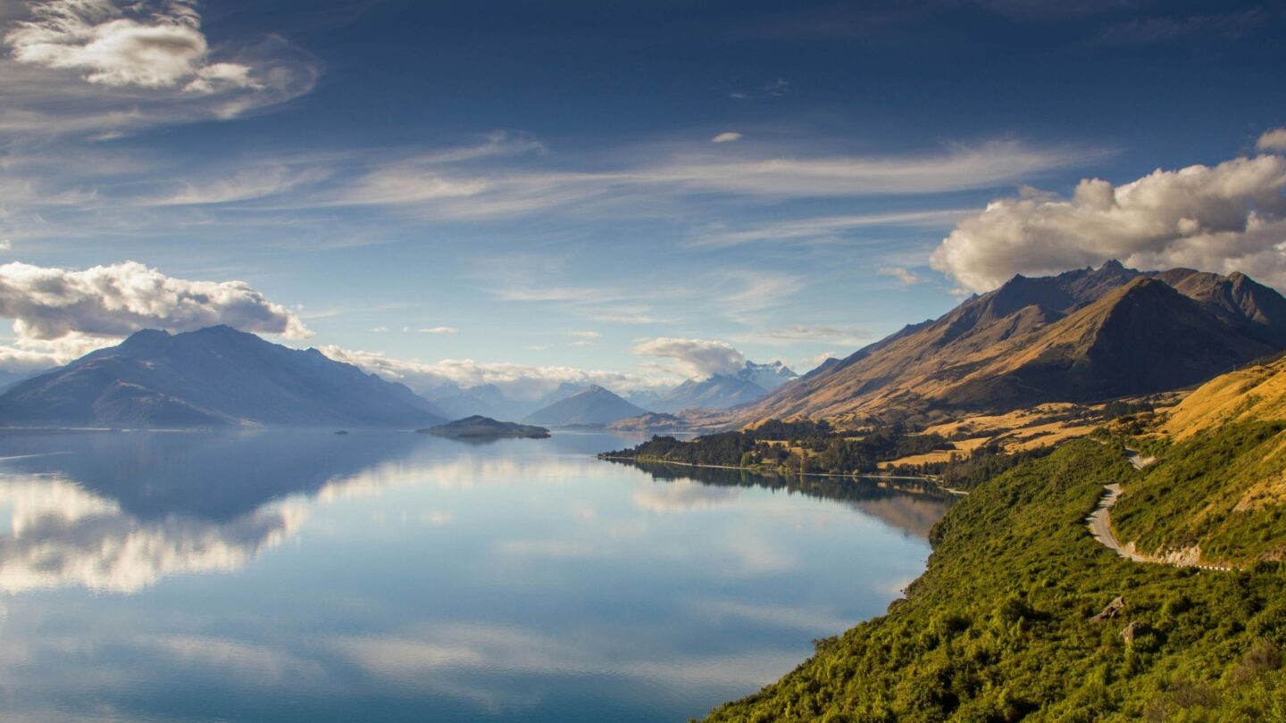 Scenic lake view surrounded by mountains under blue sky