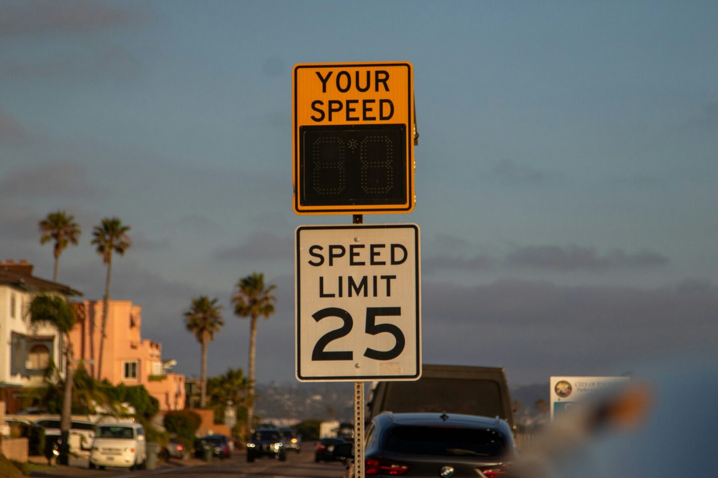 Digital speed display showing 88 above 25 mph limit sign