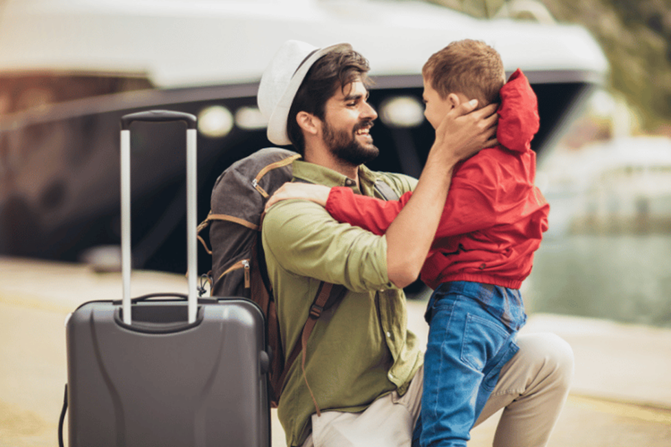 Father and son joyful reunion at harbor with luggage