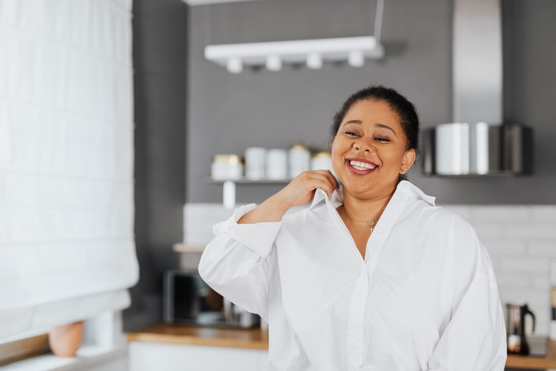 Happy woman in white shirt in modern kitchen
