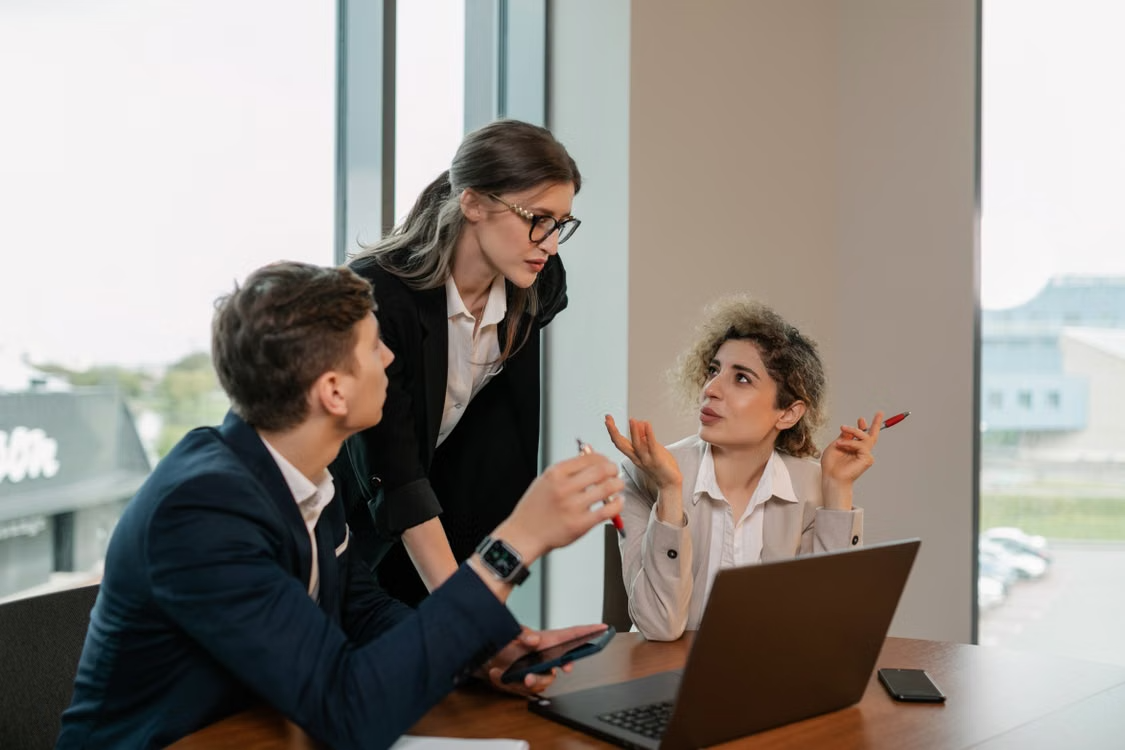 Three professionals discussing project at office table