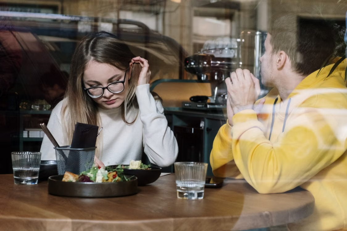 Young woman and man dining in cozy restaurant
