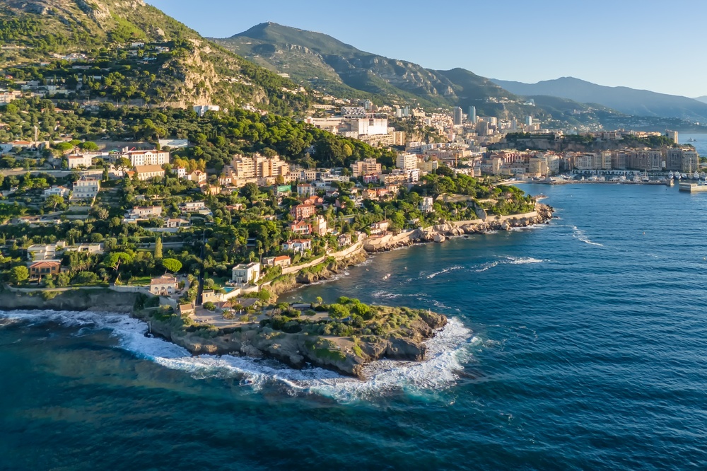 Aerial view of coastal city with lush hills and sea