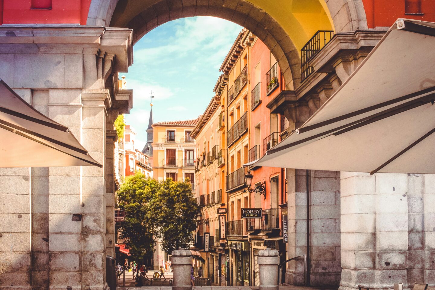 Historic arch framing colorful European street scene