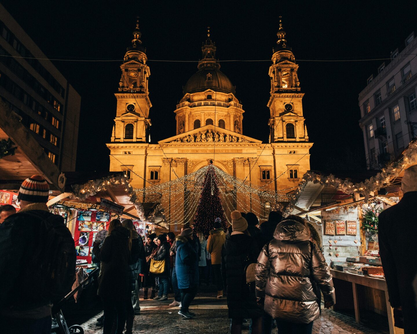 Crowded holiday market at night in front of historic church