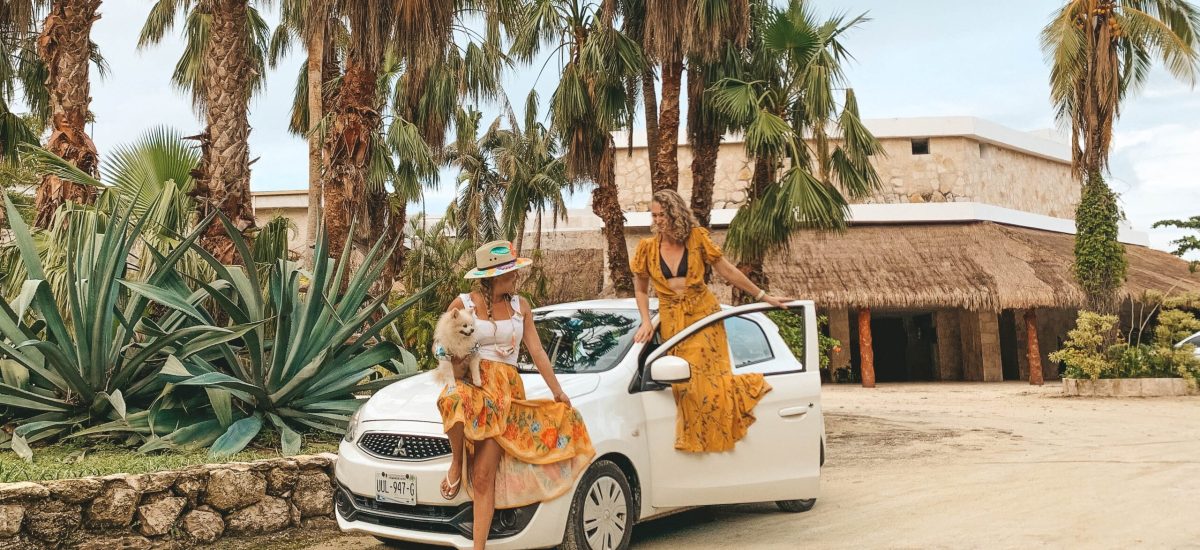 Two women standing next to a car on a dirt road in Cozumel, Mexico.